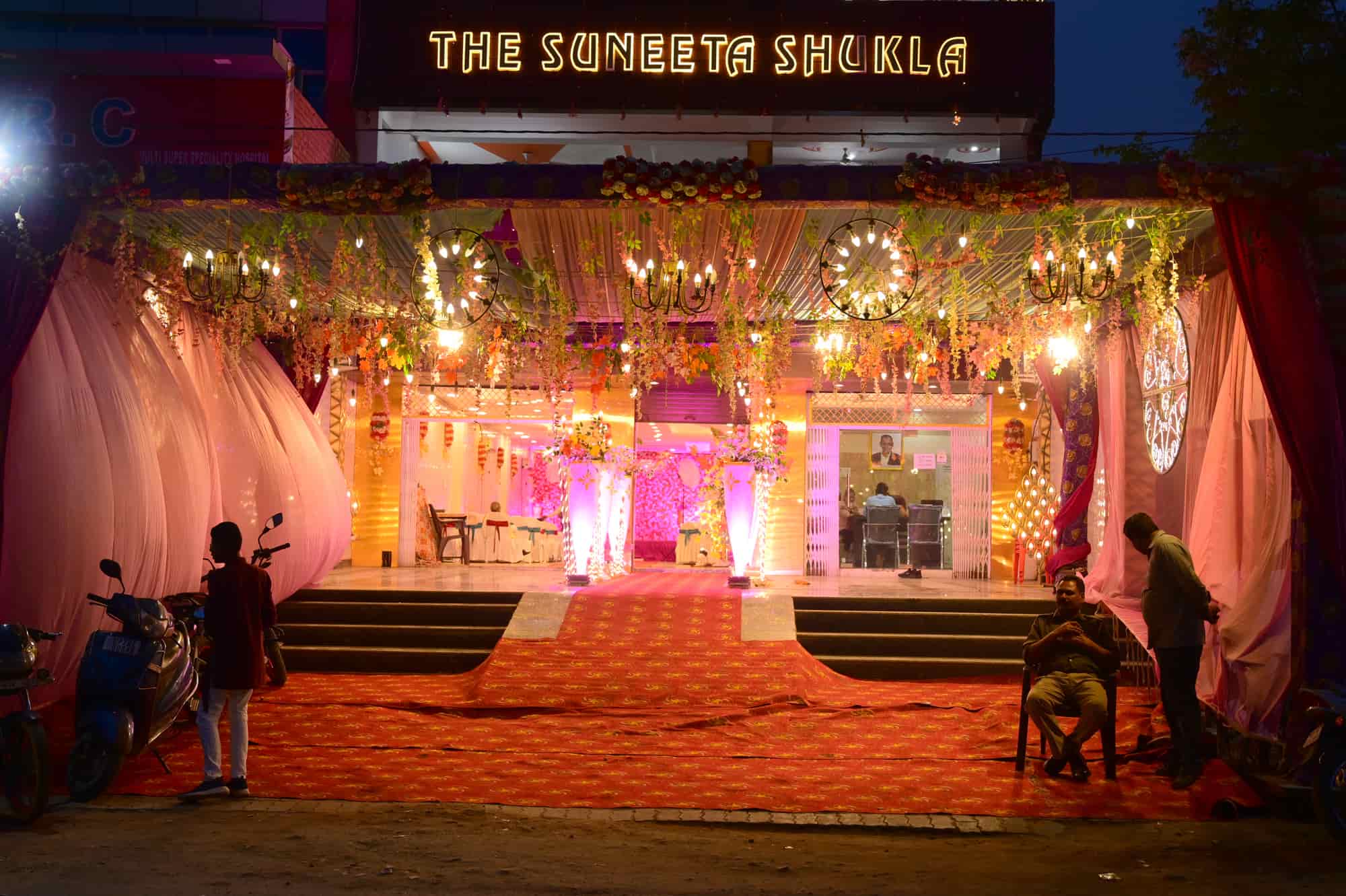 Entrance at night with floral canopy and chandeliers